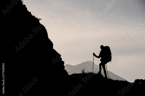 Silhouette of female hiker walking on mountain