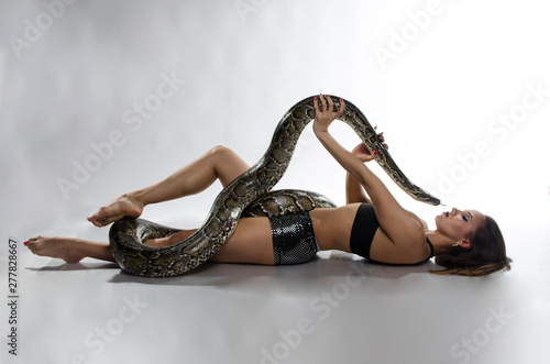 Sexy woman and tiger python in the studio