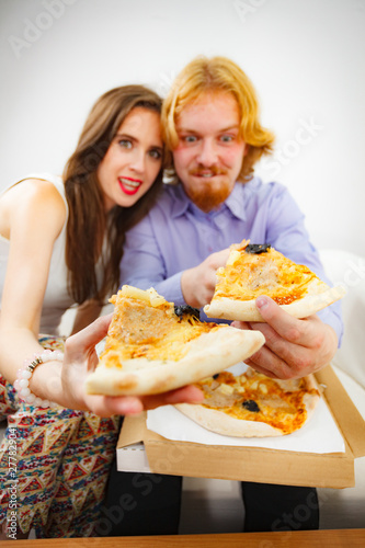 Funny couple eating pizza