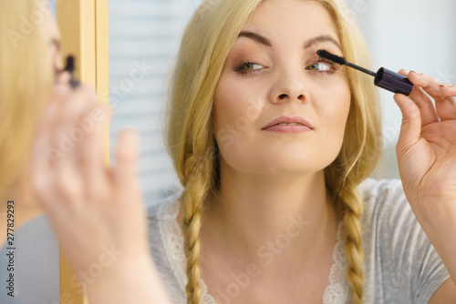 Woman using mascara on her eyelashes