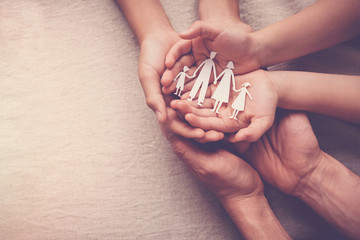 Adult and children hands holding paper family cutout, family home,adoption foster care, homeless support, mental health Autism, household budget cost of living inflation concept