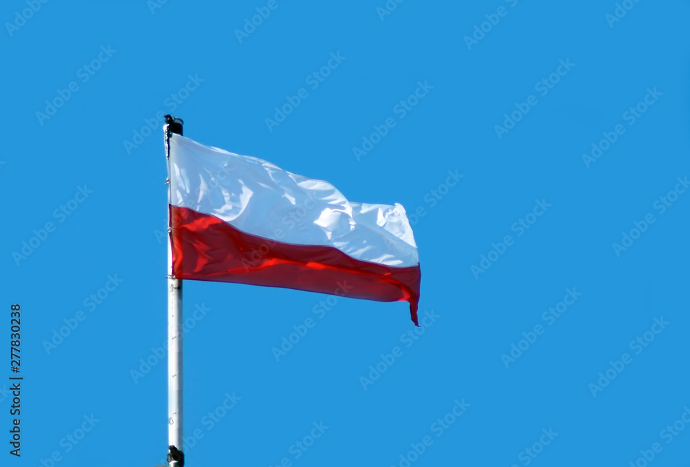 Flag of Poland in blue sky.