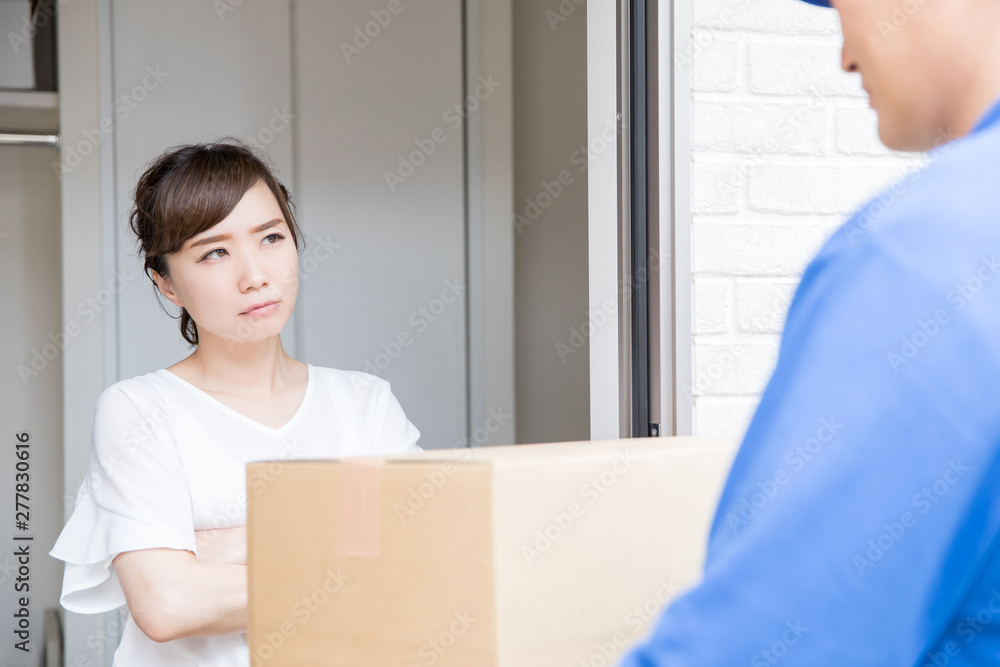 ダンボールが届いて怒る女性 ダンボールが届いて怒る女性