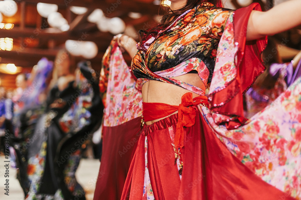 Gypsy dance festival, Woman performing romany dance and folk songs in  national clothing. Beautiful roma gypsy girls dancing in traditional floral  dress at wedding reception in restaurant Stock Photo
