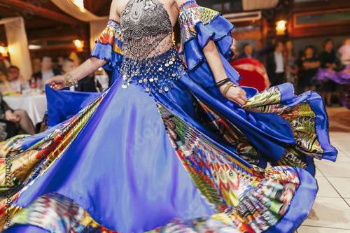Beautiful gypsy girls dancing in traditional colorful clothing. Roma gypsy festival. Woman performing romany dance and singing folk songs in national dresses at wedding reception