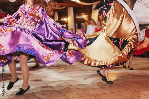 Gypsy dance festival, Woman performing romany dance and folk songs in national clothing. Beautiful roma gypsy girls dancing in traditional floral dress at wedding reception in restaurant