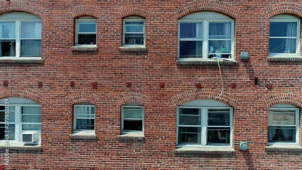 Fun upward tracking drone shot of side of red brick apartment building with windows. 4k Fun upward tracking drone shot of side of red brick apartment building with windows. 4k