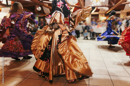 Gypsy dance festival, Woman performing romany dance and folk songs in national clothing. Beautiful roma gypsy girls dancing in traditional floral dress at wedding reception in restaurant