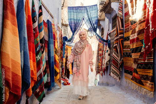 Tourist on a street with carpets - Chefchaouen, Morocco © kotelnyk