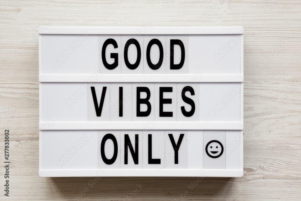 'Good vibes only' words on a modern board on a white wooden background, top view. From above, overhead, flat lay. Close-up. 'Good vibes only' words on a modern board on a white wooden background, top view. From above, overhead, flat lay. Close-up.