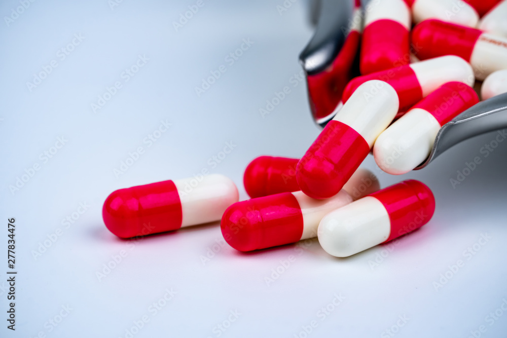 Red-white pills on stainless steel drug tray and on white table. Pharmacy drugstore background. Pharmaceutics concept. Pharmaceutical industry. in hospital. Global drug market. Stock-foto | Stock