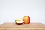 glass of apple juice and apple on wooden table on white background