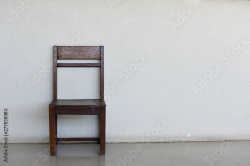 Old wooden chair on the old wall background