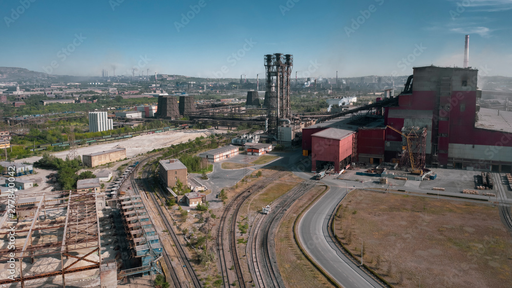Concept of environmental pollution, drone view of smokestack pipe steel plant, aerial industrial panoramic landscape with blue sky and autumn vegetation, air emissions from manufacturing sector,Russia