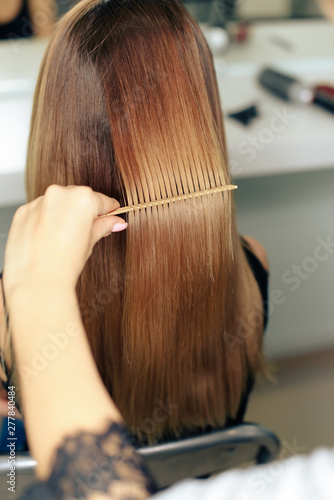 stylist's work with the hair of a girl in a beauty salon