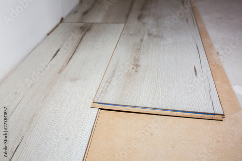 Laminate flooring in apartment. Maintenance repair works renovation. Restoration of wooden parquet planks indoors.