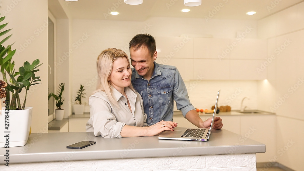Fototapeta premium Business couple in kitchen woman using laptop