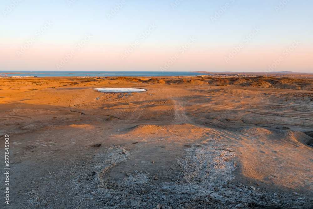 Mud volcano crater at sunset time