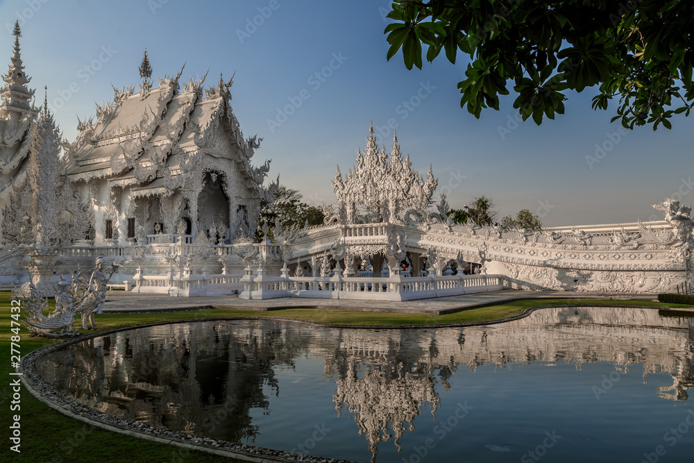 Wat Rong Khun, Weisser Tempel in der Abendsonne mit Schatten und Wasserspiegelung, Chiang Rai Thailand