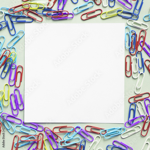 Square shaped white cardboard paper surrounded by many paper clips