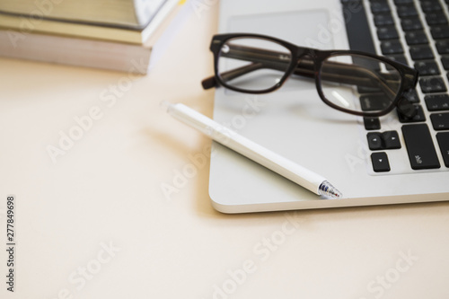 Close-up of pen and eyeglasses on laptop keypad