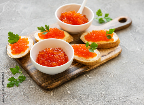 Red caviar in bowl and sandwiches