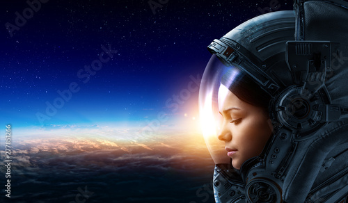 Female astronaut in space on planet orbit. © Sergey Nivens