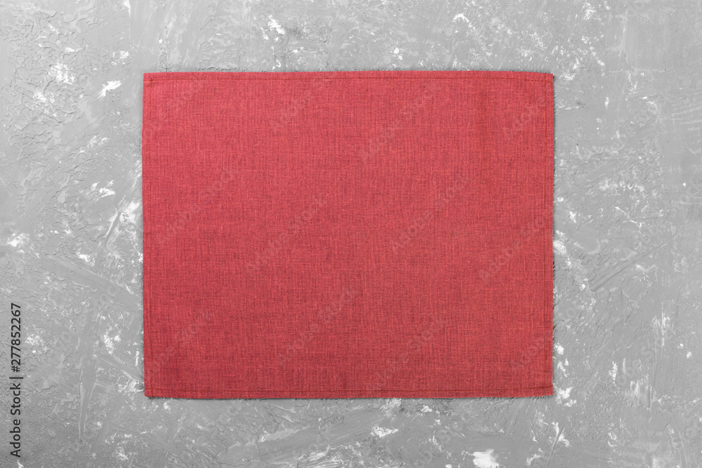 Fototapeta premium red cloth napkin on rustic cement background top view with copy space