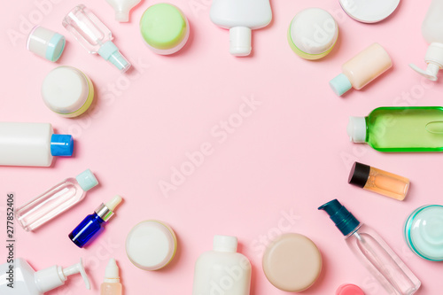 Frame of plastic bodycare bottle Flat lay composition with cosmetic products on pink background empty space for you design. Set of White Cosmetic containers, top view with copy space