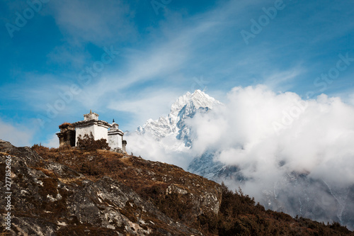 Everest trekking. In the frame stupa on the hill. The background is mountain covered by clouds. Nepal