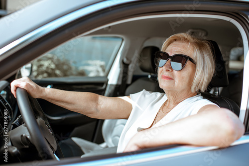 Portrait of a senior woman driver sitting in the modern car © rh2010