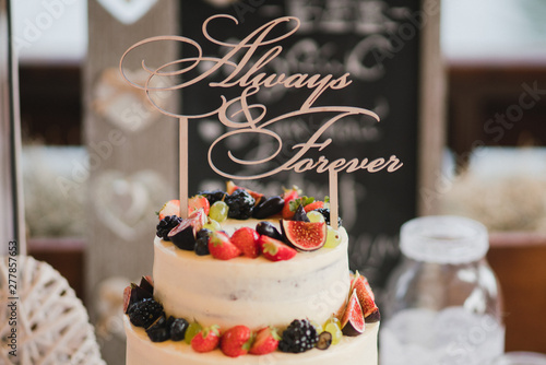 Candy bar with tasty desserts and appetizers at wedding reception. Decorated with flower compositions and candles. Sweet food  dessert  buffet  catering table  restaurant.