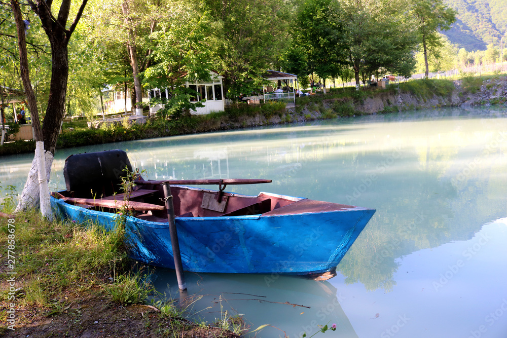 Blue boat with rake on the lake