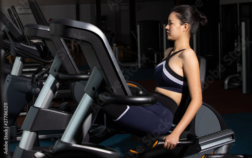 Asian slim Fitness woman black hair sport bra exercise warm up on push Pull machine Weight Muscle Hands Arms Multi Function in Fit Gym. Concept female Can Do athlete Sport healthy, copy space © Jade