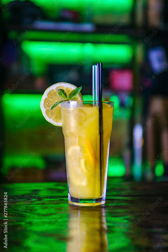 Orange cocktail in a tall glass and a slice of lemon. Orange cocktail in a tall glass and a slice of lemon.