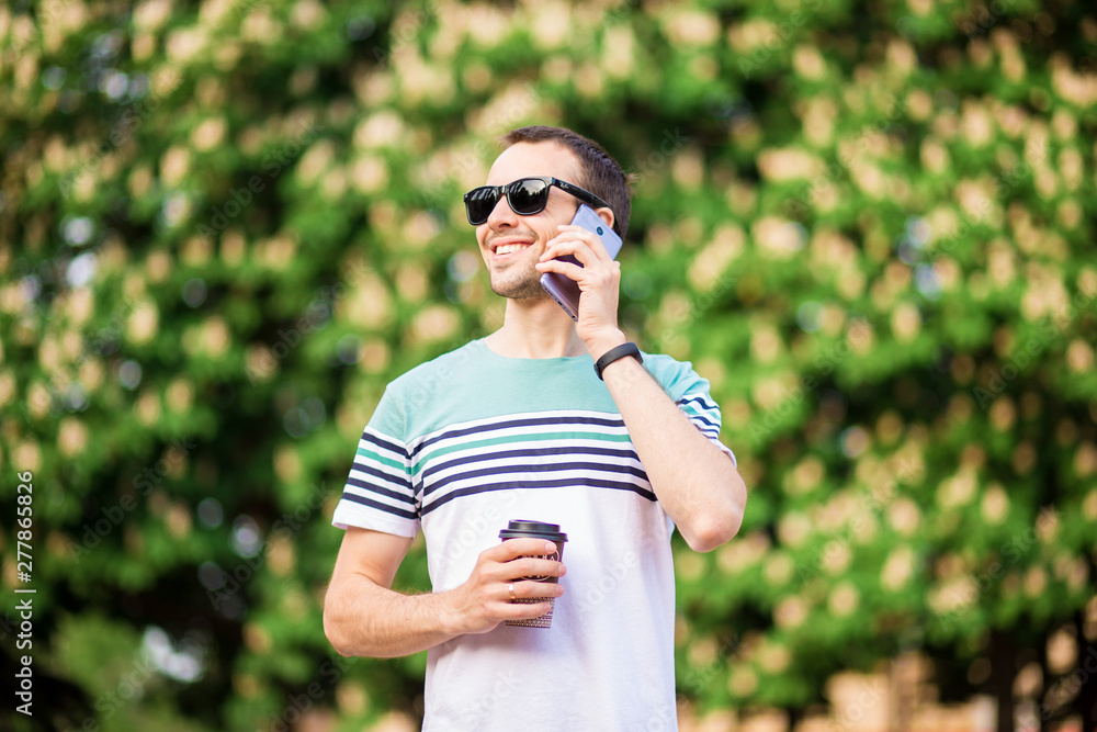 drinks, technology and people concept - close up of businessman with coffee cup and smartphone on street in the morning drinks, technology and people concept - close up of businessman with coffee cup and smartphone on street in the morning