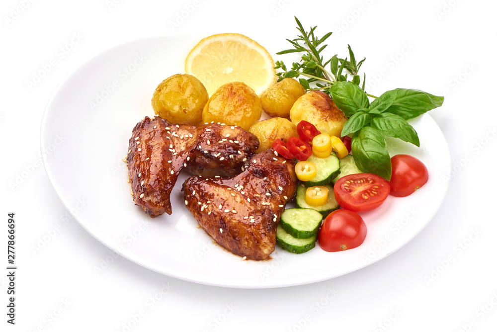 Tasty grilled chicken wings with baked potatoes, Restaurant food, close-up, isolated on white background Tasty grilled chicken wings with baked potatoes, Restaurant food, close-up, isolated on white background
