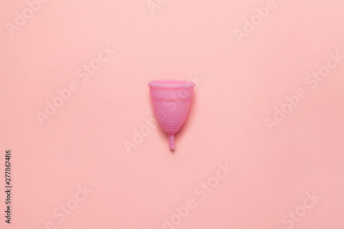 Reusable silicone menstrual cup on a soft pink background. Modern female intimate alternative gynecological hygiene. Eco zero waste concept. Copy space place for text. Flat lay photo