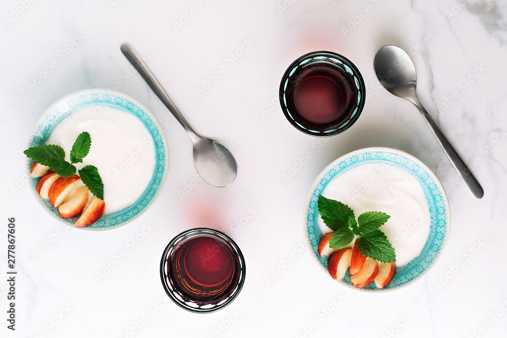 Top view of healthy breakfast of natural greek yoghurt, nectarines and juice on marble table. Flat lay. Top view of healthy breakfast of natural greek yoghurt, nectarines and juice on marble table. Flat lay.