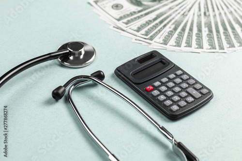 Stethoscope, money and calculator concept. Paid medicine. Health insurance costs
