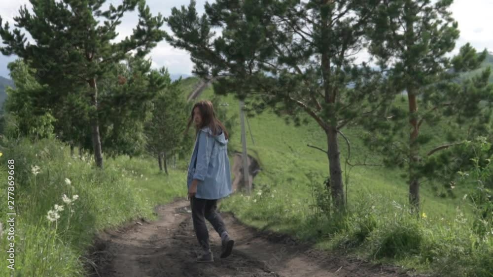 A woman descends from the mountain. Tourist sightseeing wildlife. Woman in the forest A woman descends from the mountain. Tourist sightseeing wildlife. Woman in the forest