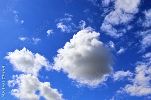 Relaxing view on fluffy white clouds on a deep blue sky photo