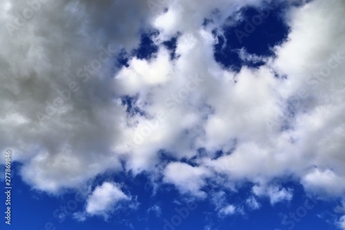 Relaxing view on fluffy white clouds on a deep blue sky photo