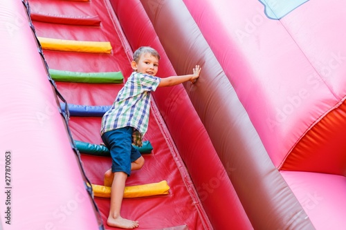 Foto having fun on the slide in the fun park in bouncy castle climbing stairs