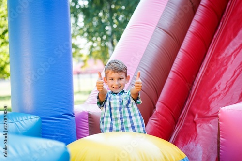 having fun on the slide in the fun park in bouncy castle climbing stairs