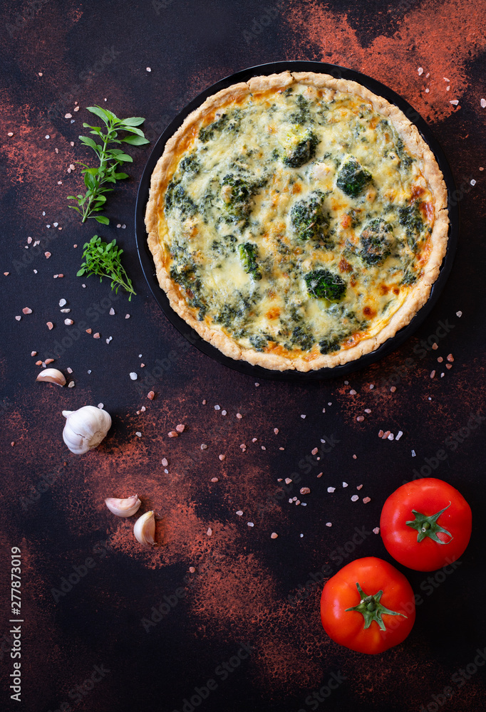 Traditional French Quiche with cheese, broccoli, spinach and chicken. Quiche lorraine. French cuisine. Top view. Dark rustic background