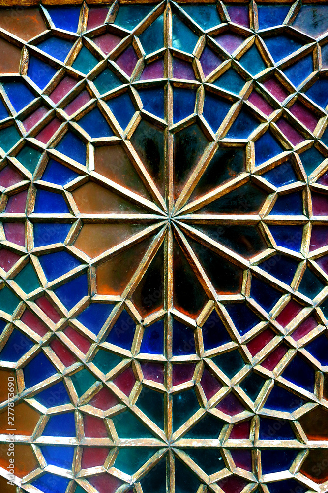 Traditional oriental window pattern made of little colorful glases. Detail of the stained glass window.