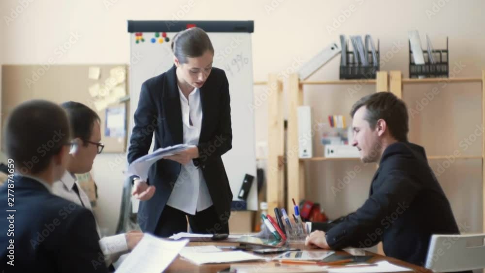 Woman boss examines her company reports and outraged, african american girl brings her more papers Woman boss examines her company reports and outraged, african american girl brings her more papers