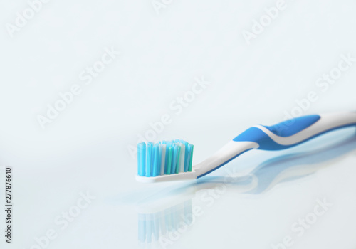 Close up view of transparent toothbrush with blue bristles on white background. Healthy teeth, dental care concept. Space for text.