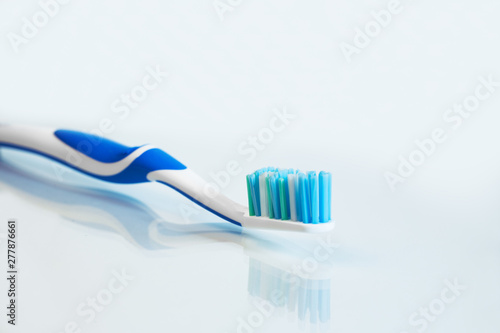 Close up view of transparent toothbrush with blue bristles on white background. Healthy teeth  dental care concept. Space for text.
